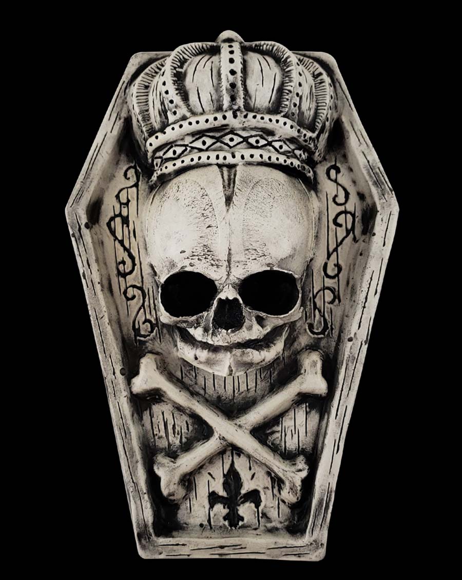 Miniature coffin with skull and crossbones wearing a crown