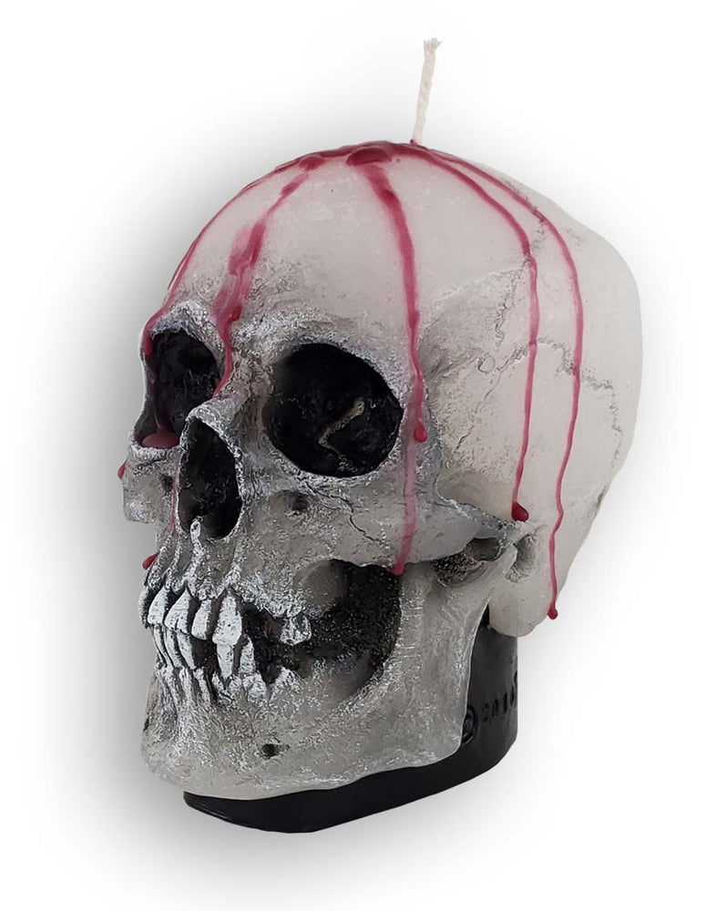 Decorative wax skull candle with dripping blood, facing left